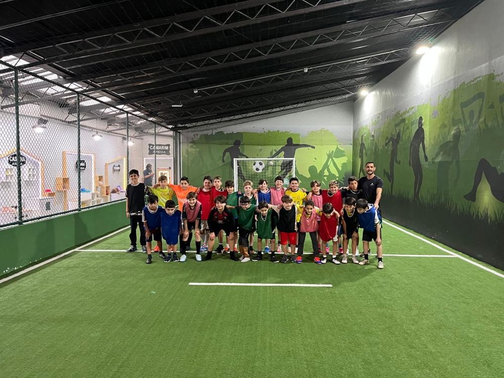 Turma reunida em arena indoor de futebol