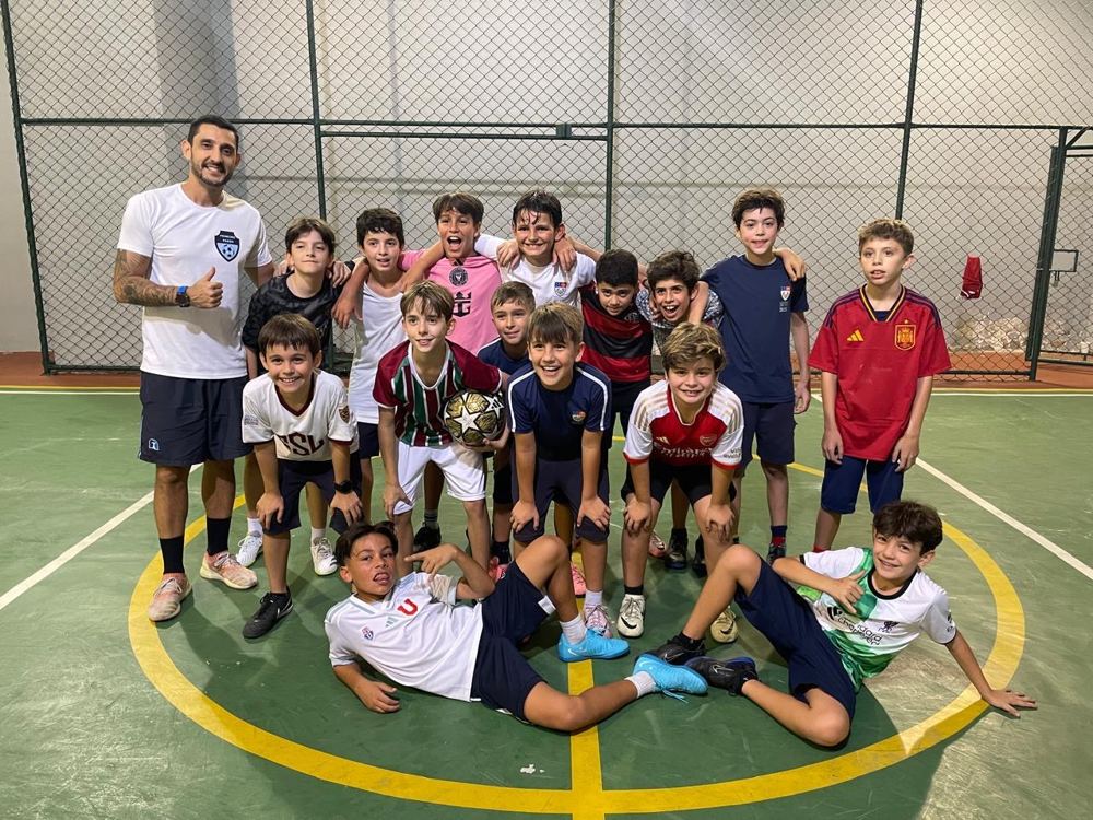 Turma posando com o professor Bruno na quadra de futsal